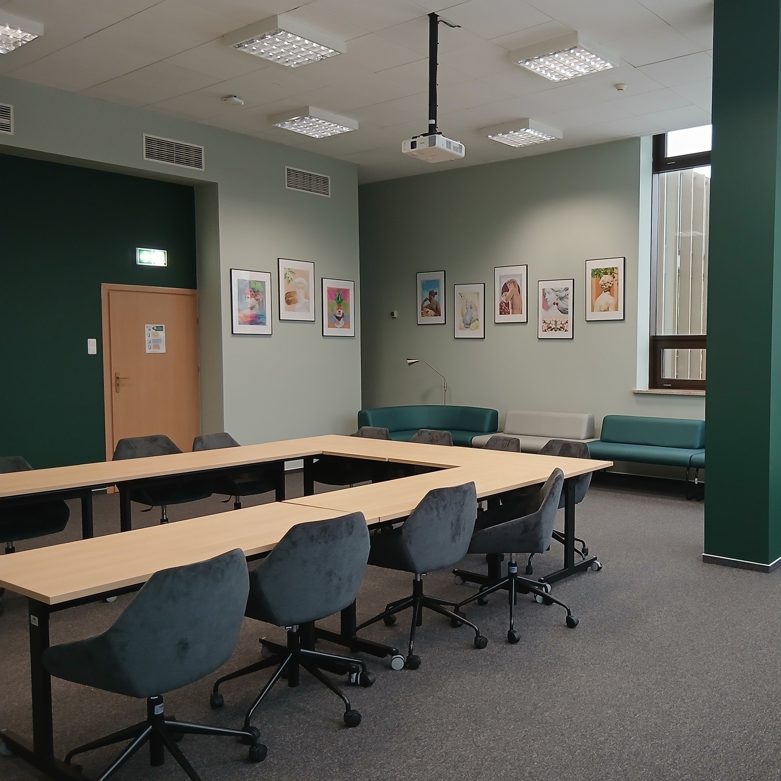 Wnętrze sali do pracy grupowej "4Team" z ułożonym w podkowę stołem, fotelami i sofami